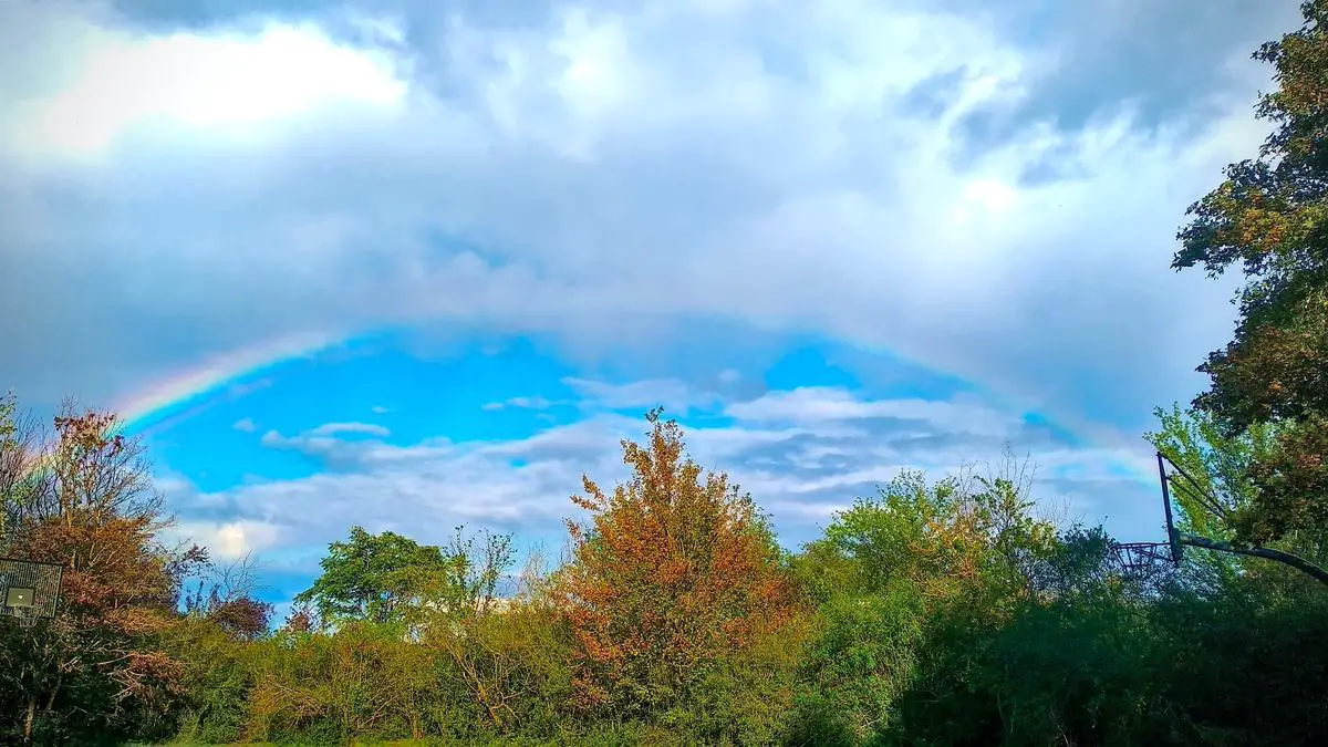 Ein Regenbogen vor einem farbenfrohen Hintergrund, der das Symbol des Regenbogens in der Populärkultur darstellt.